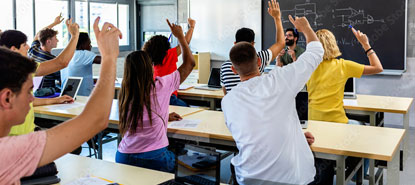 High School Students raising their hands in class