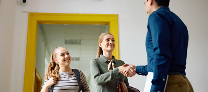 Mother and Daughter greeting a high school teacher with hand shake